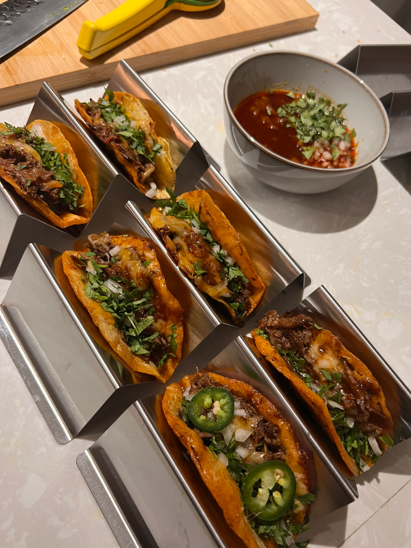 Birria tacos with melted cheese, coriander and consommé