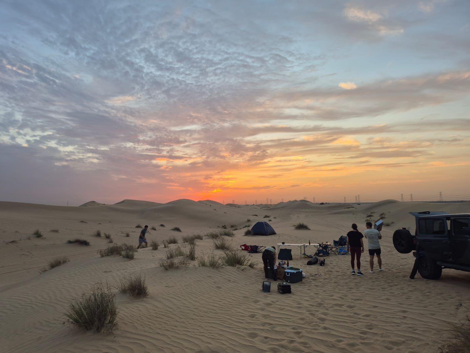 Desert camp with tent and 4x4 at sunset in the dunes near Dubai